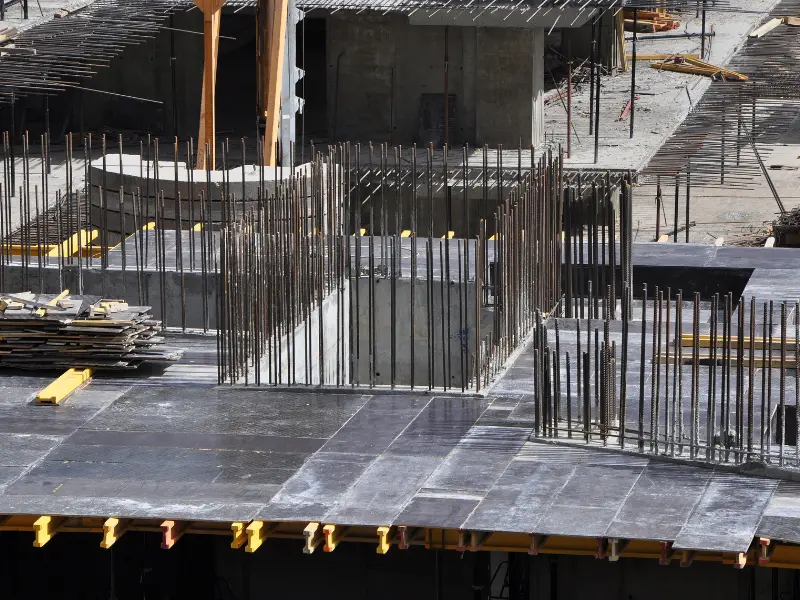 Armado de acero con varillas verticales para refuerzo de concreto en una obra civil, representativo de los materiales que provee Comenk al sector construcción.